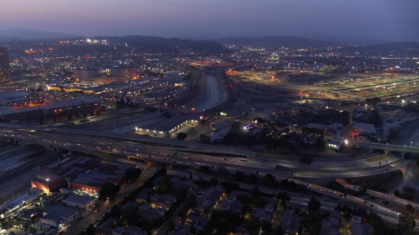 Aerial view of a city skyline with a large road full of cars