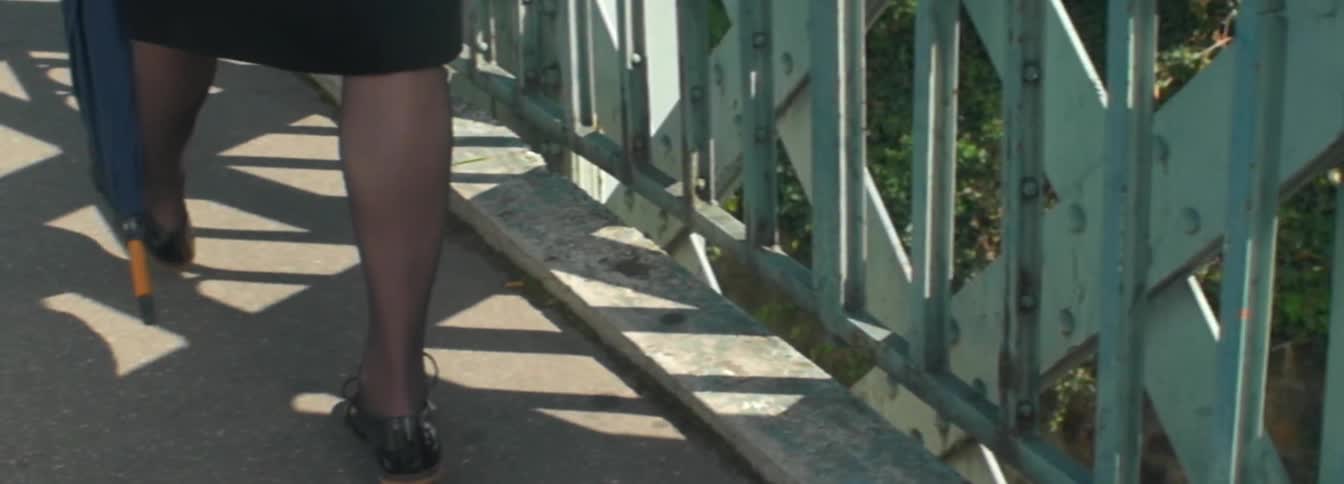 Woman's legs walking on a bridge over a ravine