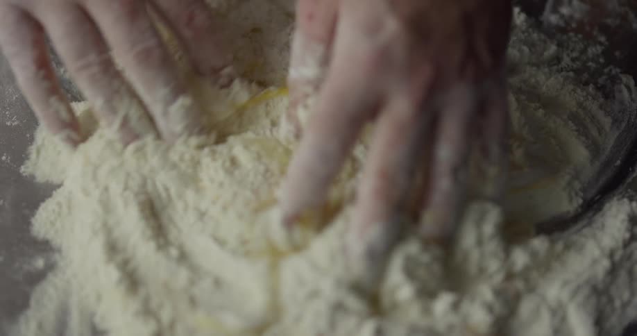A person mixes eggs into flour