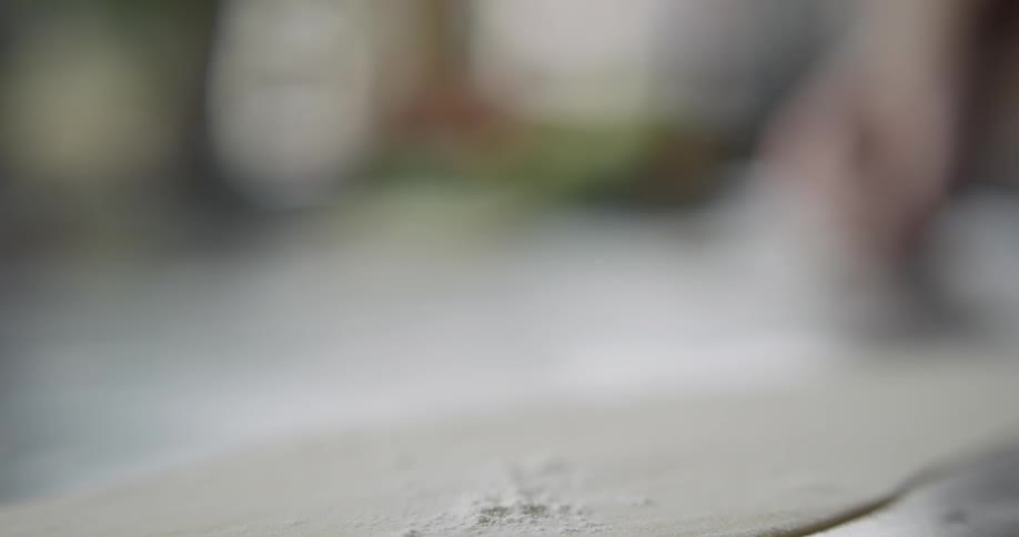 Man sprinkles flour on dough