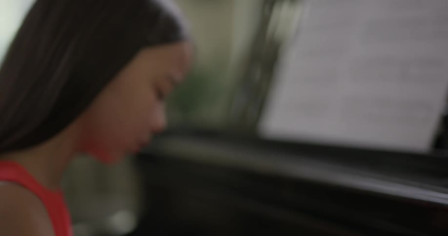 A young girl plays the piano