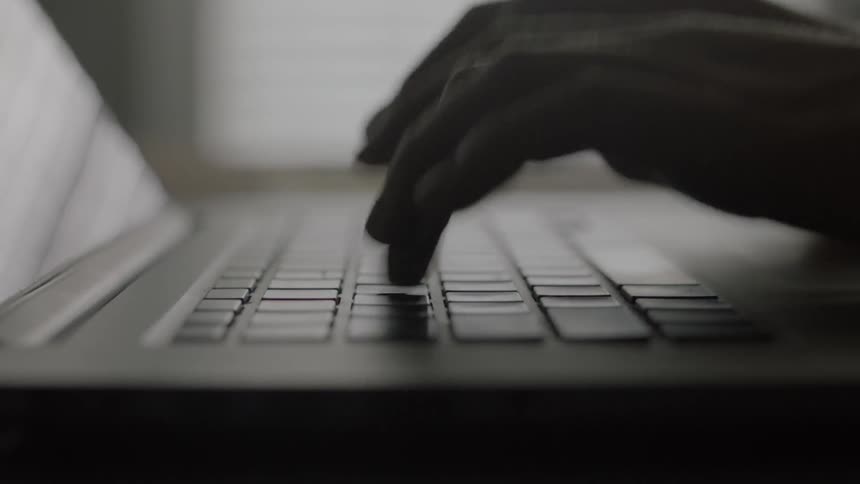 Hands typing on a laptop