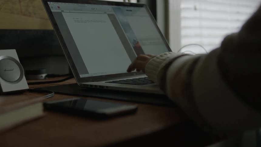 A person sitting at a desk typing on a laptop