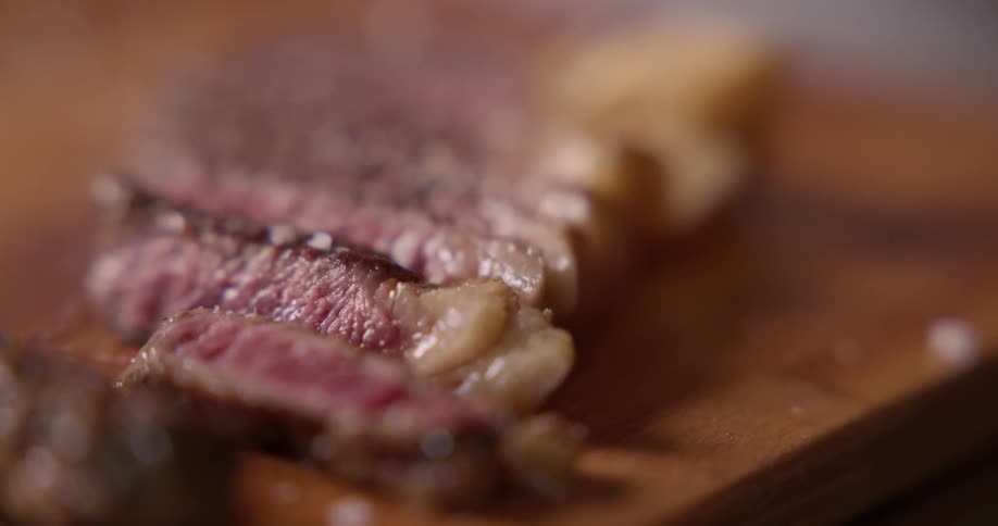 Salt being dropped on cut steak