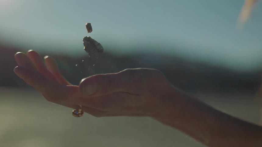 A woman bounces some rocks in her hand