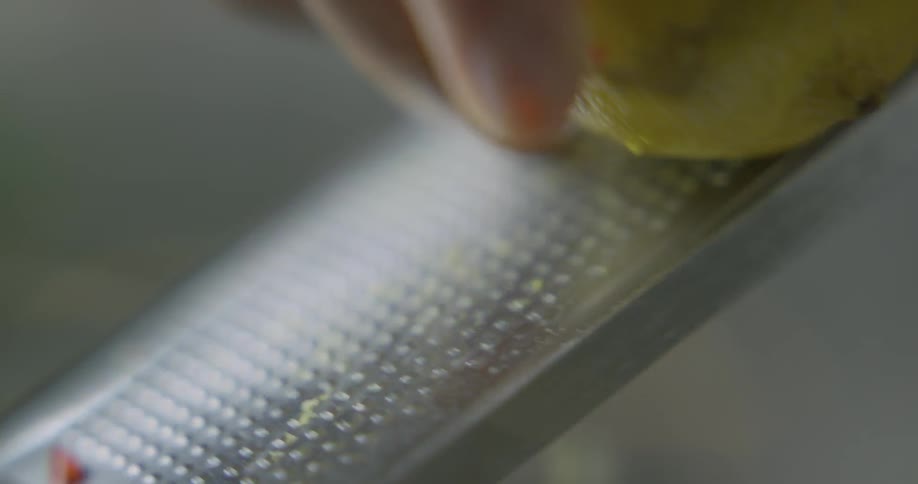 A person grates a lemon