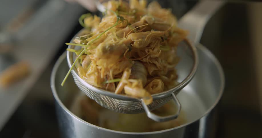 Food is being strained into a pot