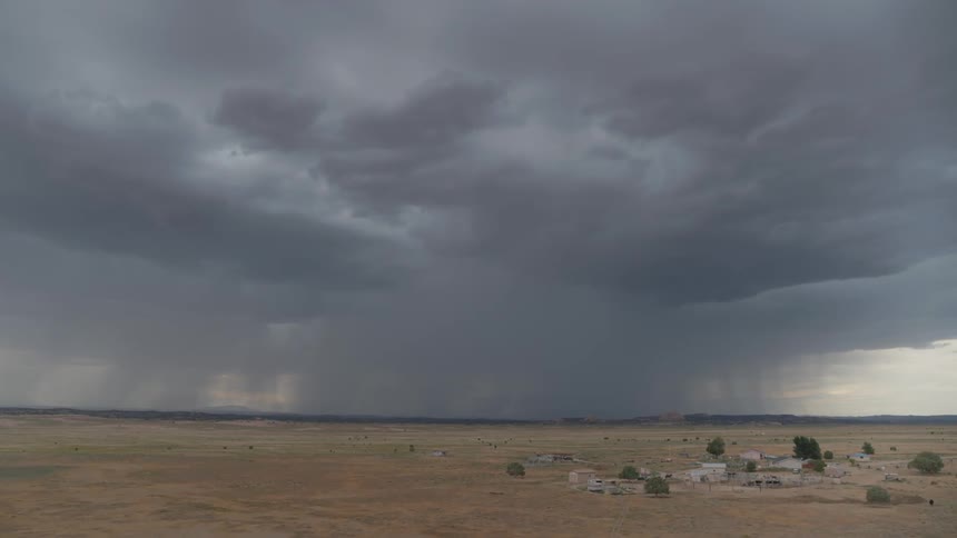 Dark clouds form over a remote town and plains