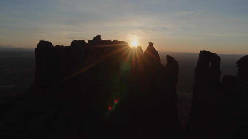 Rock pillars tower over a deserted land at sunset