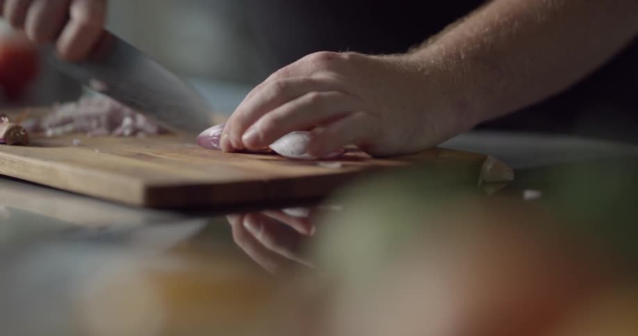 A cook finely cuts shallots