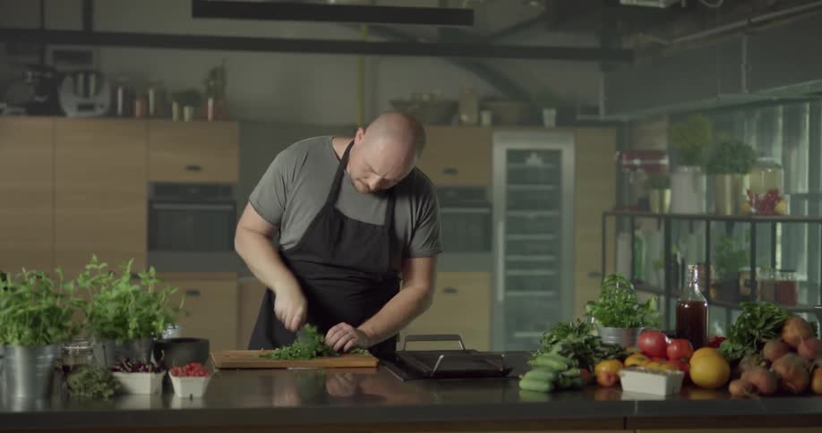 Man cuts herbs with a chef's knife