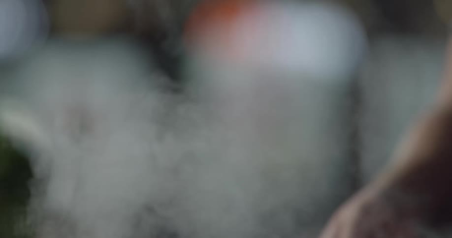 Man throws a pinch of salt into food and stirs it in the kitchen during daytime