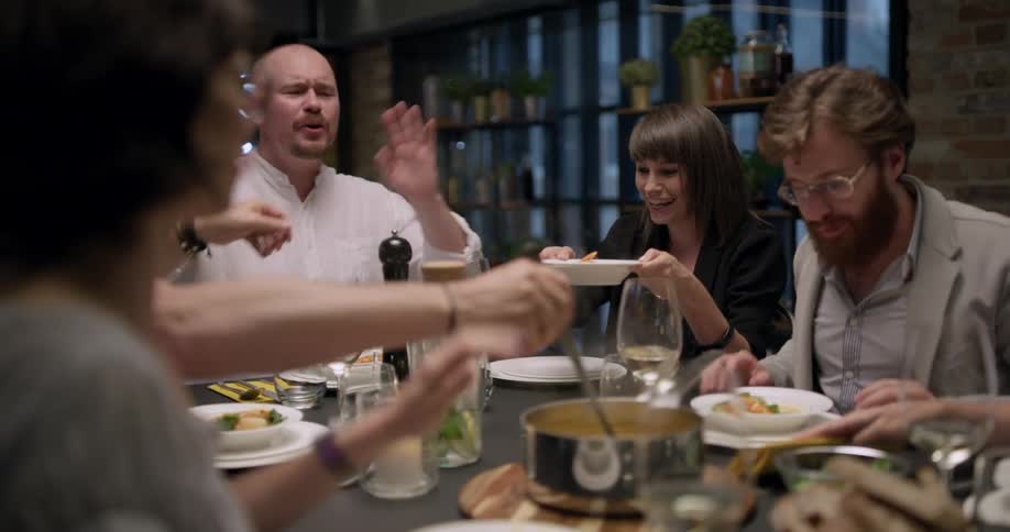 A group of people serving food and drinks at a table together