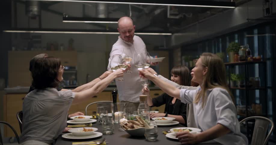 A group of men and women having wine and dinner together