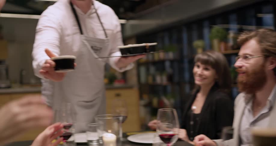 A chef serves cupcakes to people