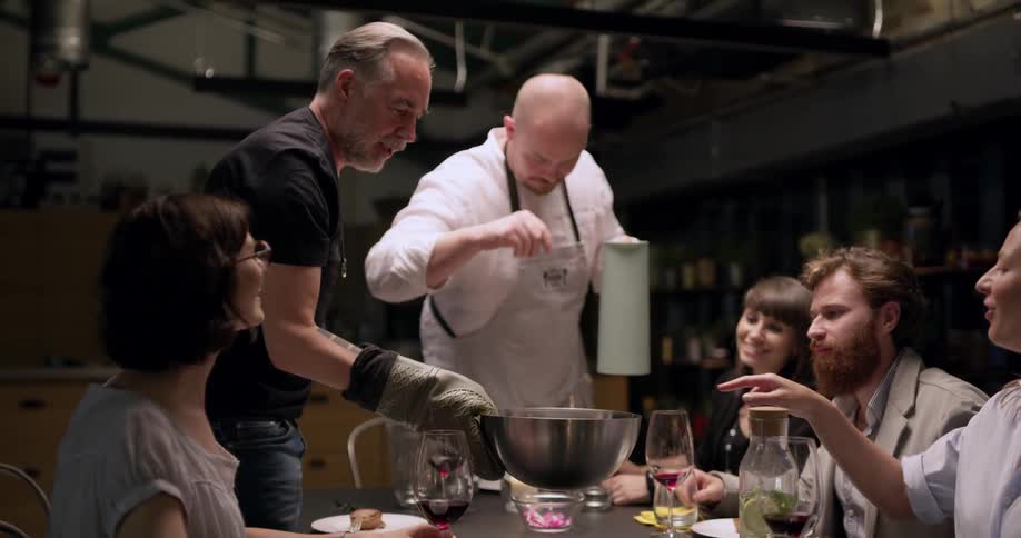 People prepare dish at dinner party