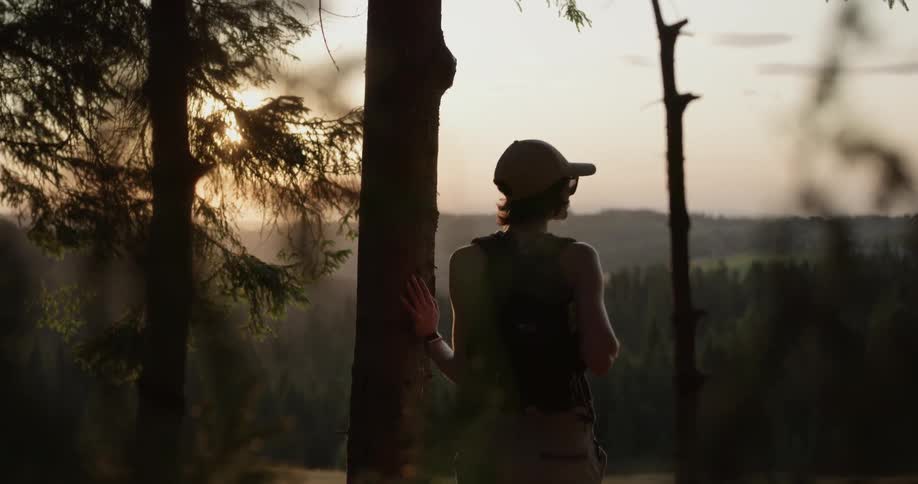 Female hiker stopping to look around during a hike at sunset