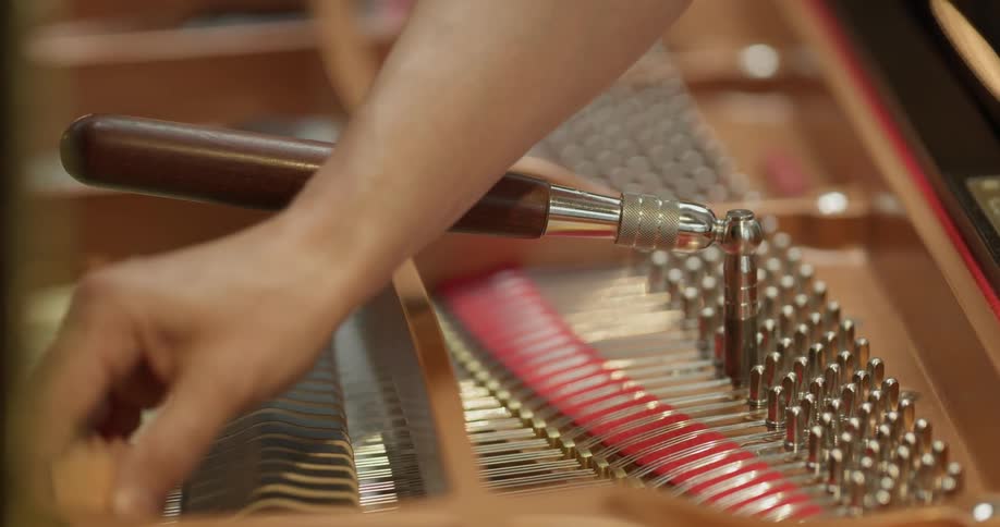 A person is working to fix a piano