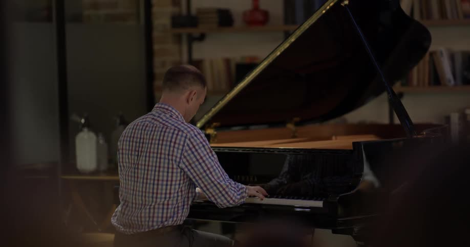 Man playing a baby grand piano