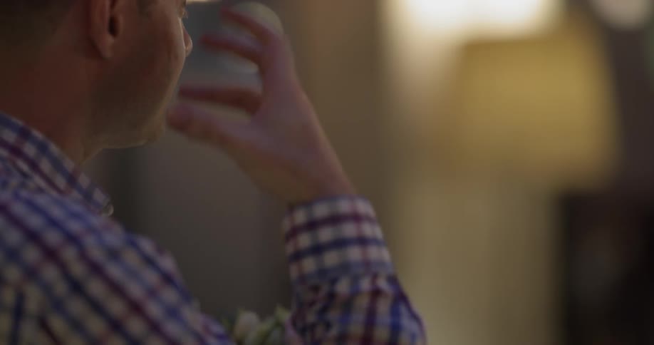 Man talking and gesturing while holding a flower bouquet