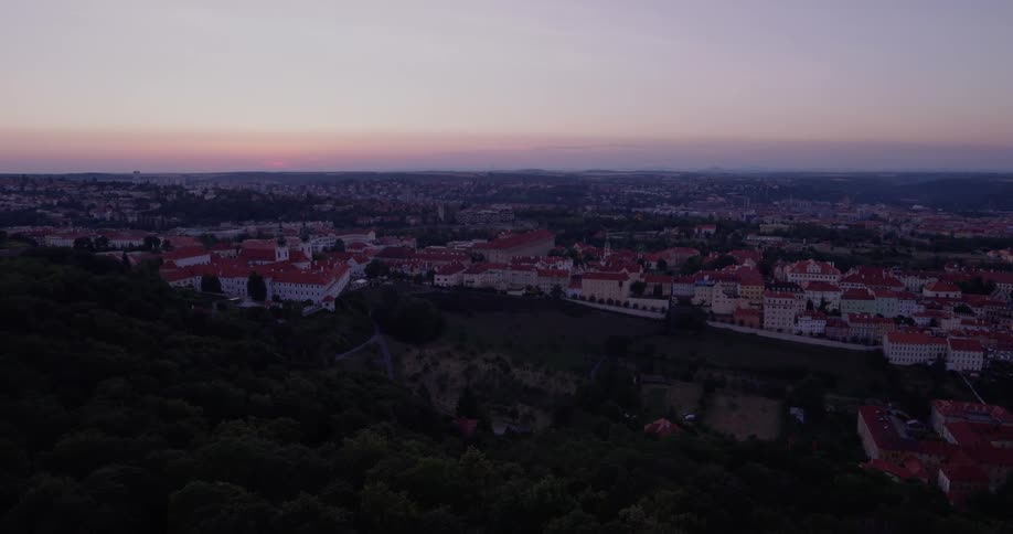 The city is down the green hill at sunset