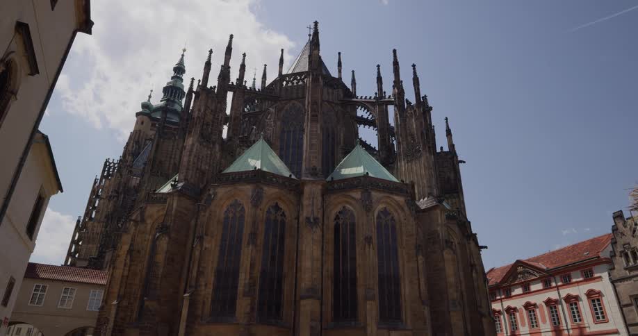 People walk back and forth in front of a cathedral in a city