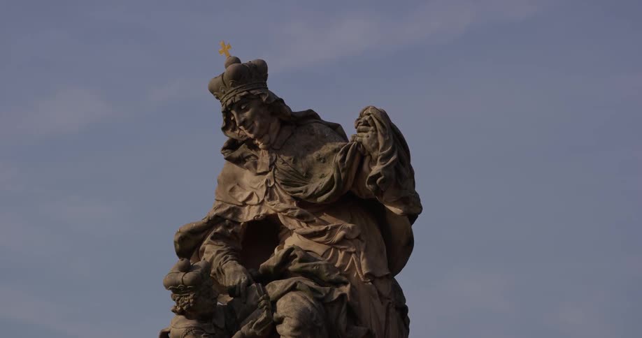 A statue is standing high in the sky