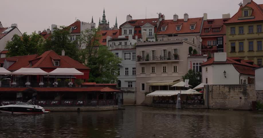 Traveling past docked boats cafes and row houses on a canal