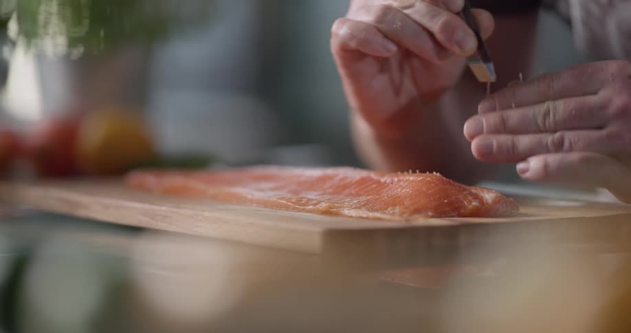 A man is removing bones from a fish