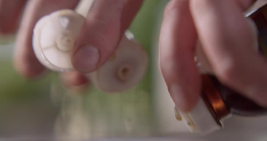 Person adds liquid from two bottles to a mixture