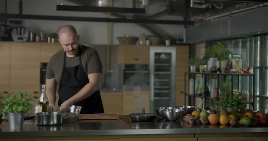 The cook grates some lemon on top of the cooked dish in the kitchen during daytime