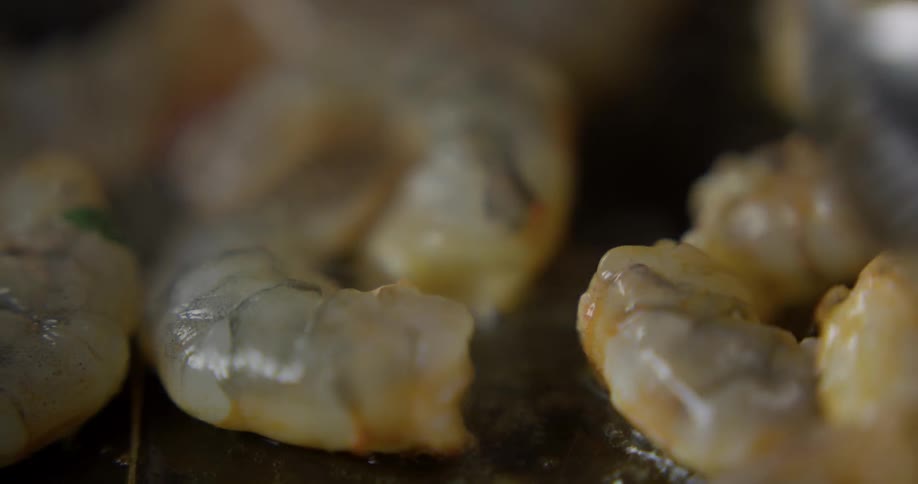 A chef sauteing shrimp in butter