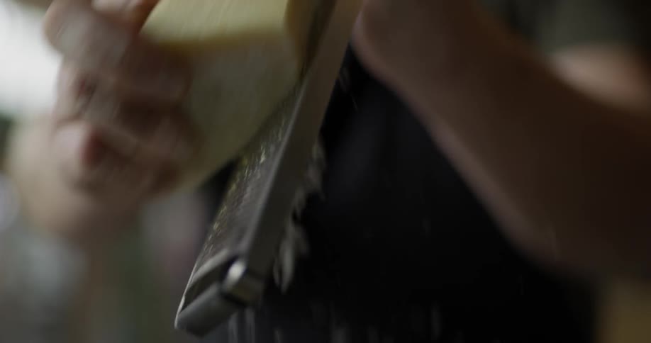 A block of cheese being grated