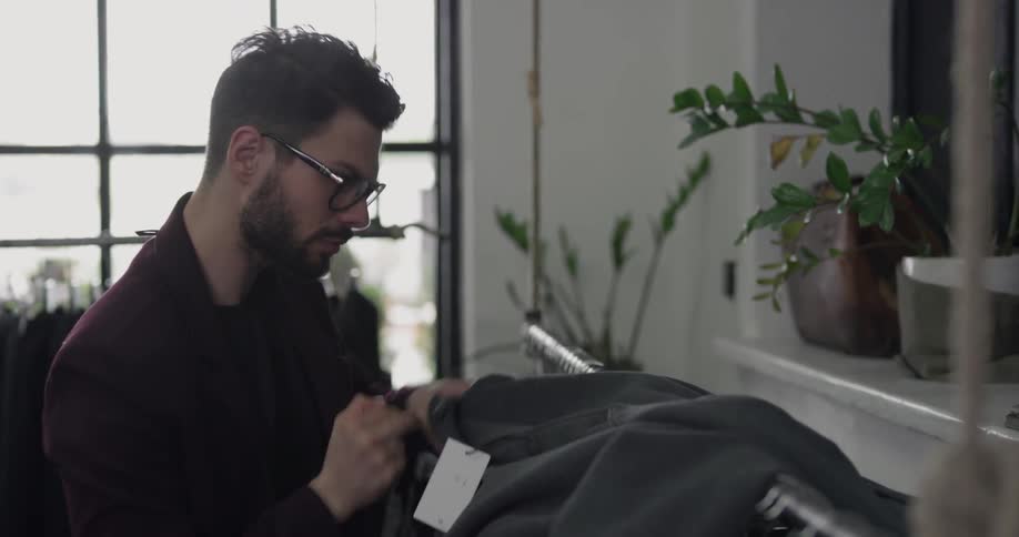 A man is looking at clothes in a store