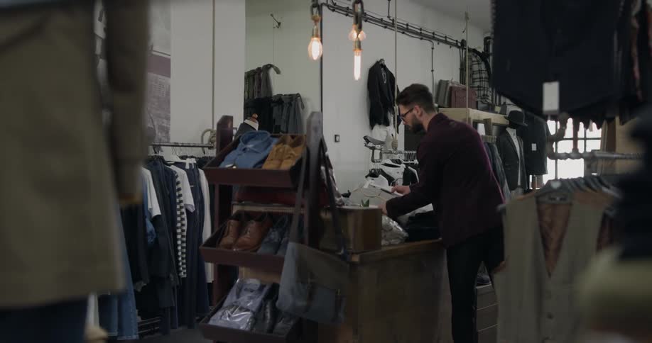 A tailor working on his workshop filled with suits and mannequins