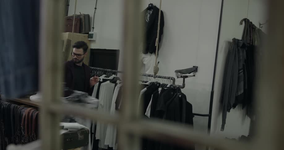 A man is in a store looking at clothes