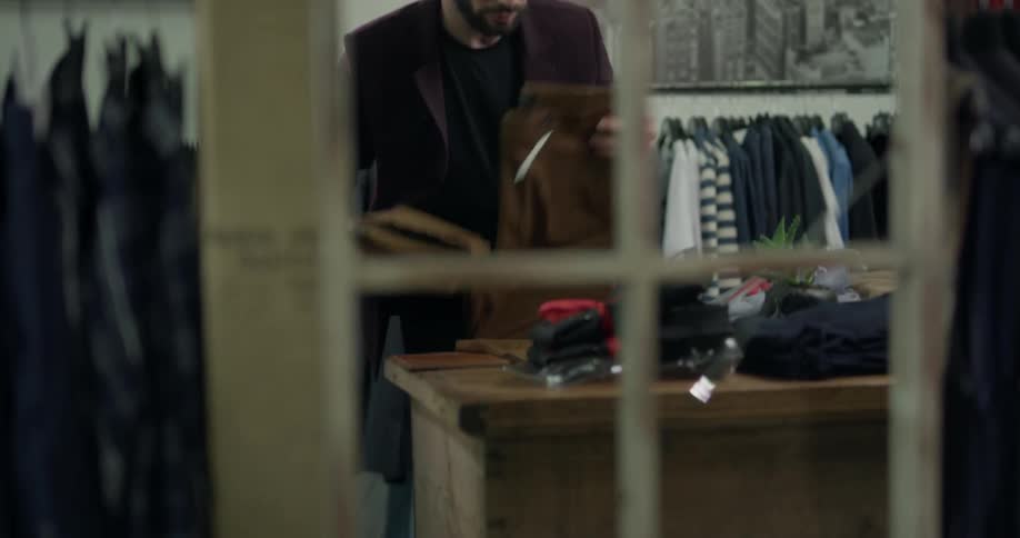 A tailor folding pants on his workshop