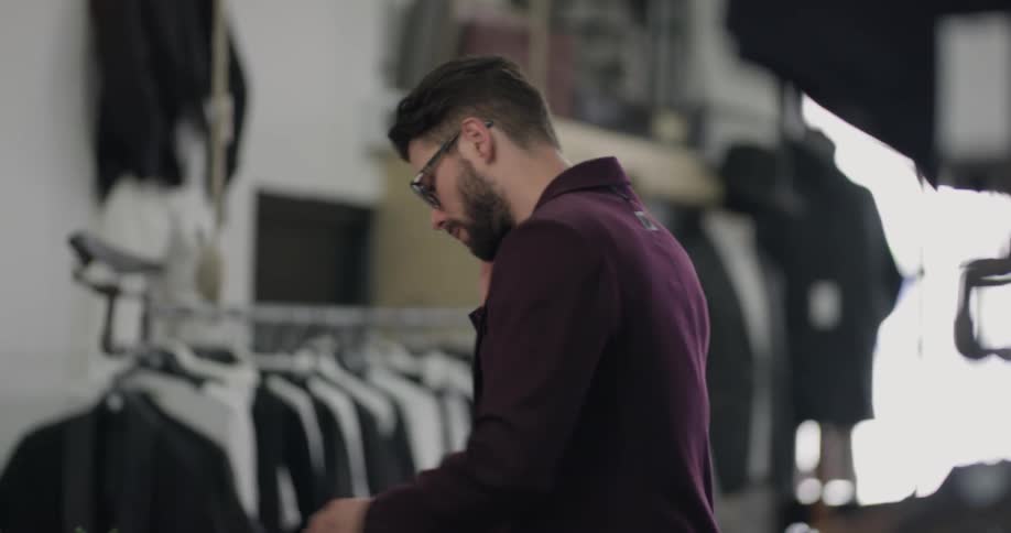 Man in suit shop talks on cell phone