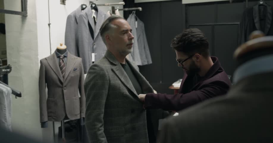 A man tries on a jacket to check how it fits