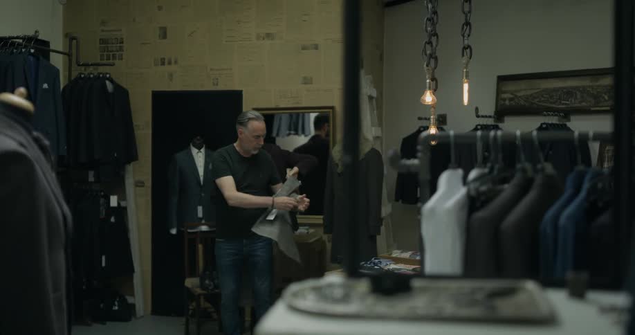 A man fitting a double breasted blazer on a customer