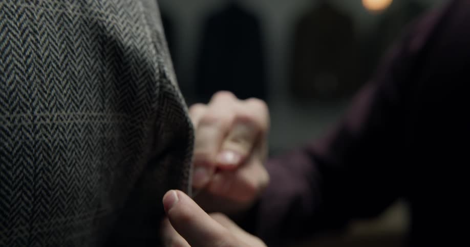 A man puts pins in a suit