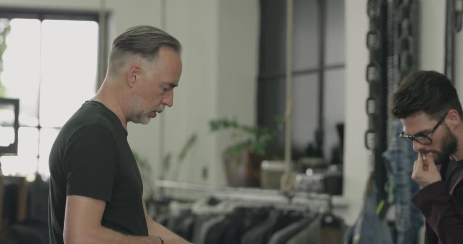 A tailor talking to a client on his shop