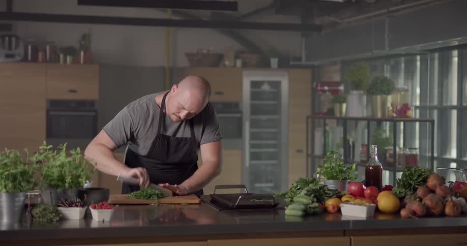 A man quickly chops fresh herbs