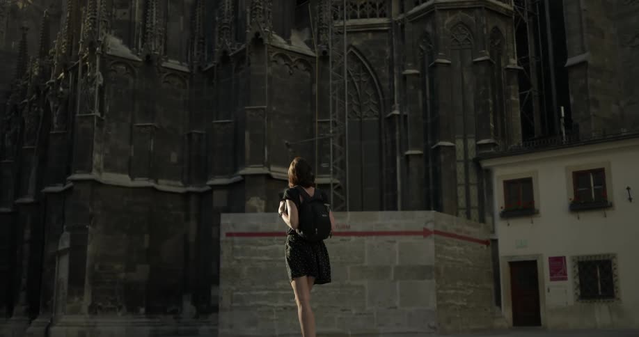 Woman looks at the huge gothic cathedral