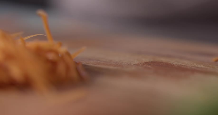 Man chops carrot on the cutting board in the kitchen during daylight