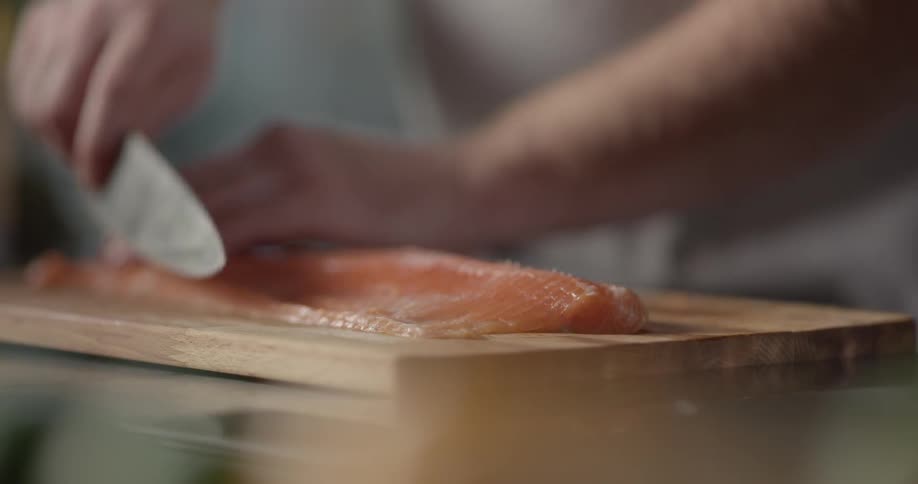 A person thinly cutting a piece of meat