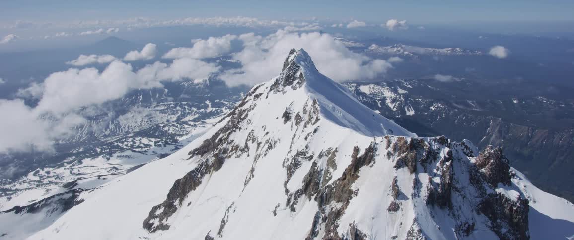 The camera flies over a snowy peak
