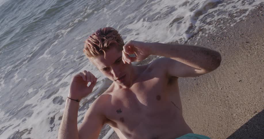 A man is doing sit ups by the beach