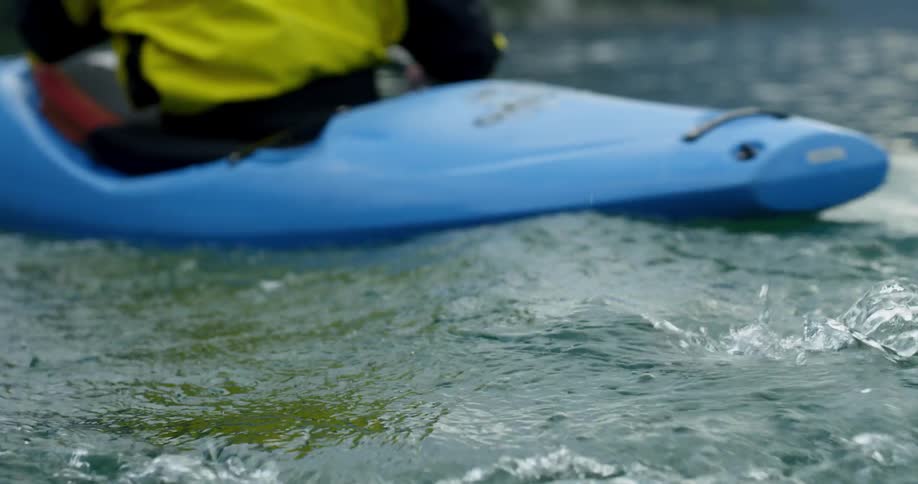 A white man steers his kayak through a lake