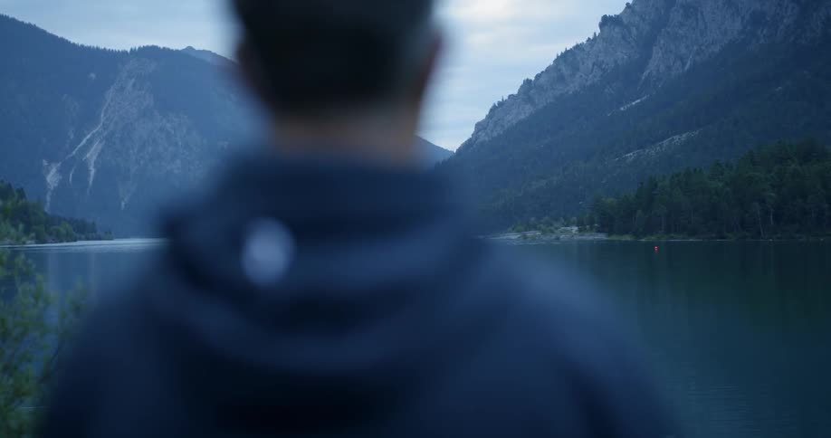 Man looks over a lake and mountains